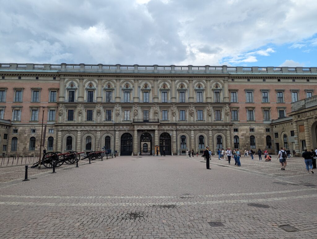 Der Königspalast, zu sehen viele Fenster, eine graurote Fassade und Ornamente an den Fenstern in der Mitte.