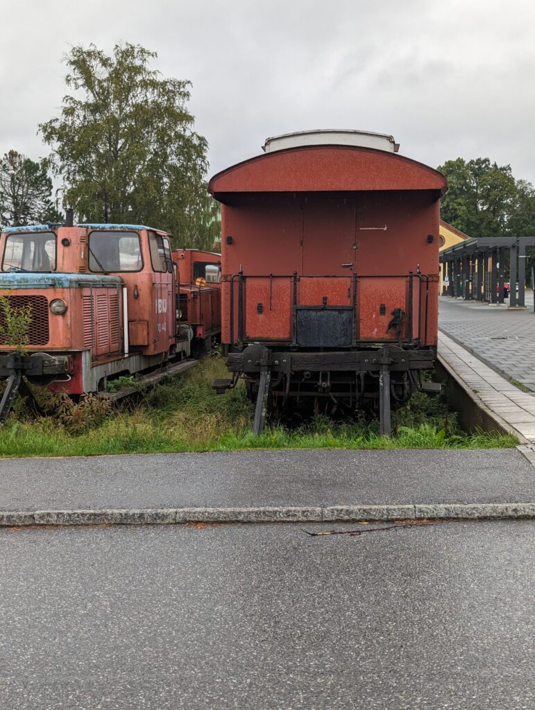 Blick auf einen Güterwaggon, links daneben eine Diesellok